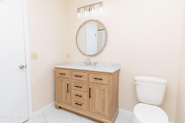 half bathroom with baseboards, toilet, marble finish floor, and vanity