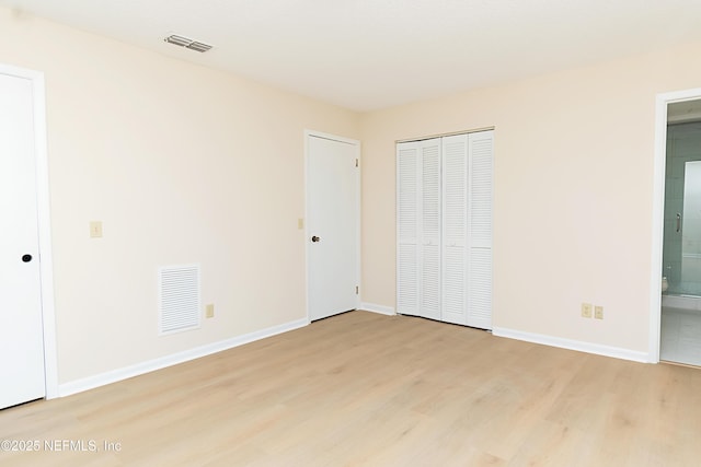 unfurnished bedroom featuring light wood-style floors, visible vents, and baseboards