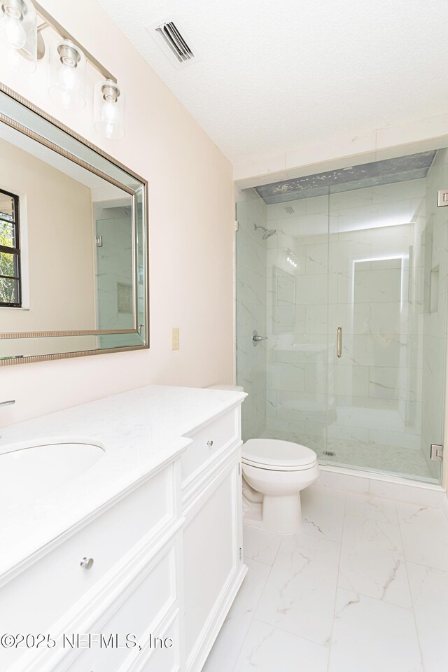 bathroom featuring visible vents, toilet, marble finish floor, a shower stall, and vanity