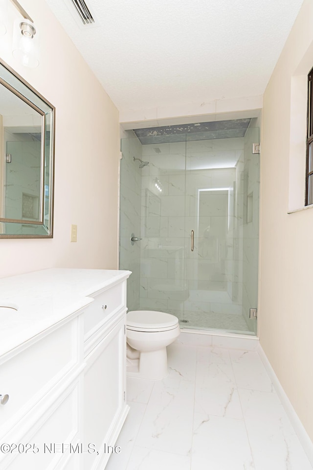 full bath featuring toilet, marble finish floor, a stall shower, and vanity