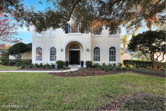 view of front facade featuring stucco siding and a front yard