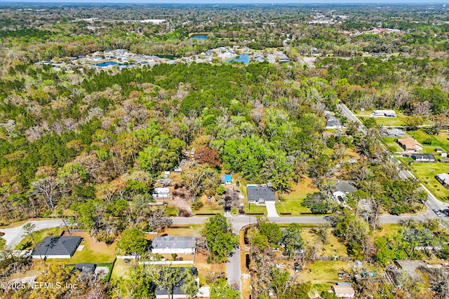 drone / aerial view with a forest view and a water view