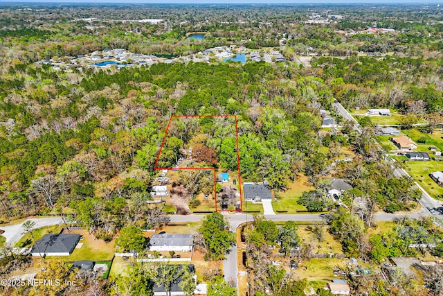 birds eye view of property featuring a water view and a wooded view