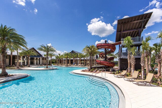 pool with a patio and a water slide