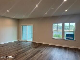 empty room with recessed lighting, baseboards, and dark wood-style flooring