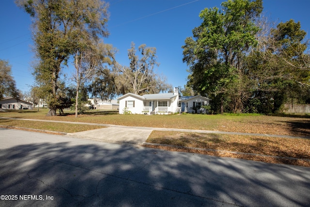 view of front of home with concrete driveway and a front yard