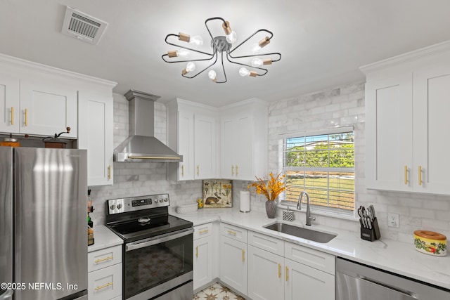 kitchen with visible vents, decorative backsplash, stainless steel appliances, wall chimney exhaust hood, and a sink