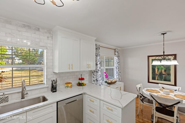 kitchen featuring white cabinets, dishwasher, ornamental molding, and a sink