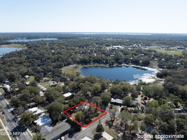 birds eye view of property with a wooded view and a water view