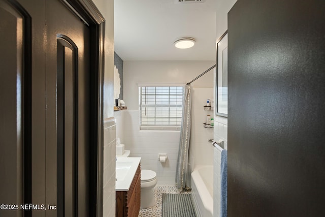 bathroom with vanity, visible vents, tile walls, toilet, and tile patterned floors