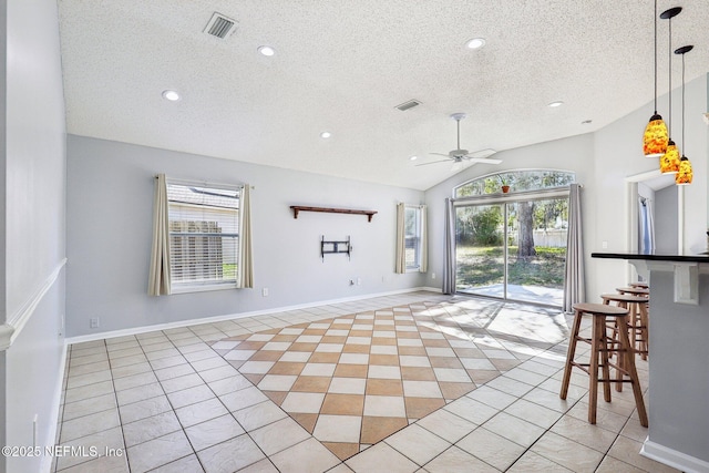 interior space with visible vents, light tile patterned flooring, a ceiling fan, and vaulted ceiling