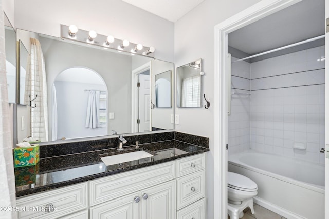 bathroom with vanity, tile patterned floors, toilet, and shower / washtub combination