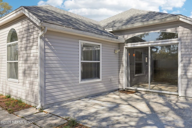 back of house featuring a patio and a shingled roof