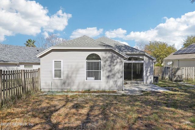 back of house featuring a lawn, a patio, a fenced backyard, cooling unit, and a shingled roof