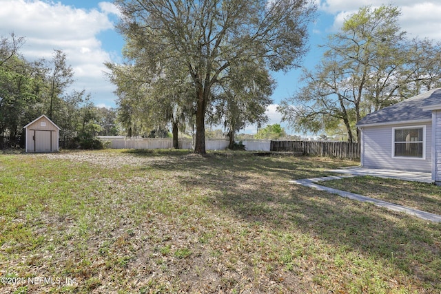 view of yard with a storage shed, a fenced backyard, and an outdoor structure