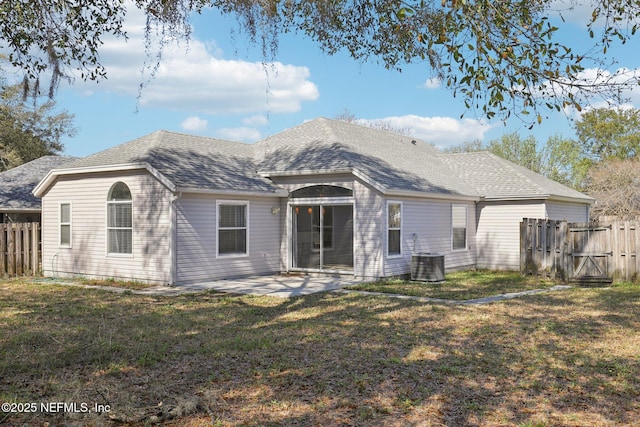 rear view of house featuring a patio, fence, a yard, cooling unit, and a shingled roof