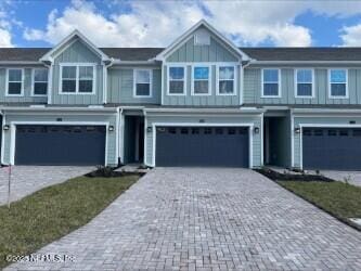 view of front of home featuring board and batten siding, an attached garage, and decorative driveway