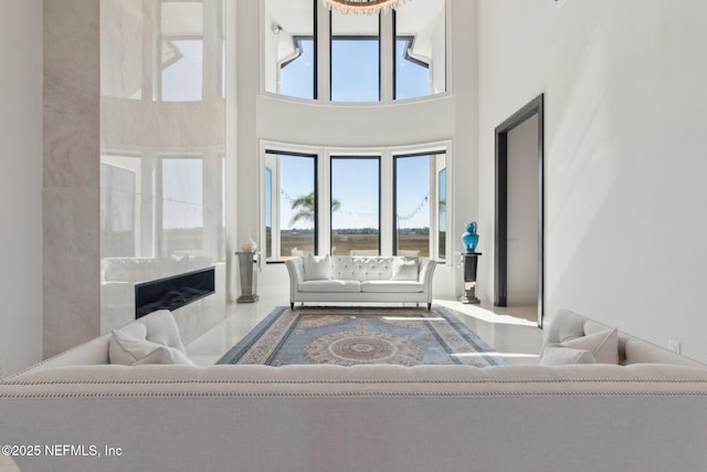 living room with a towering ceiling and a high end fireplace