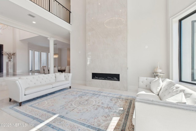 living area with visible vents, a high ceiling, and a fireplace