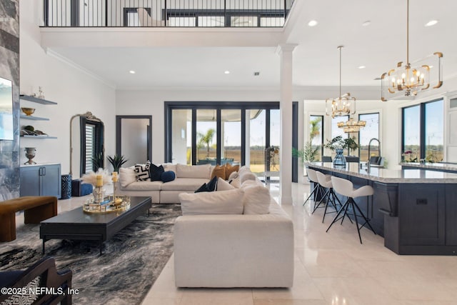 living area with light tile patterned floors, recessed lighting, a towering ceiling, crown molding, and a notable chandelier