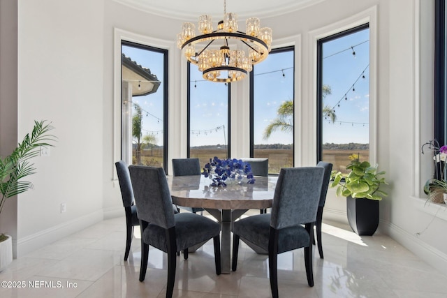 dining space featuring baseboards and an inviting chandelier
