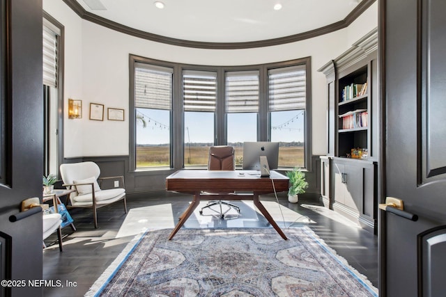 office area with a decorative wall, wood finished floors, wainscoting, and ornamental molding