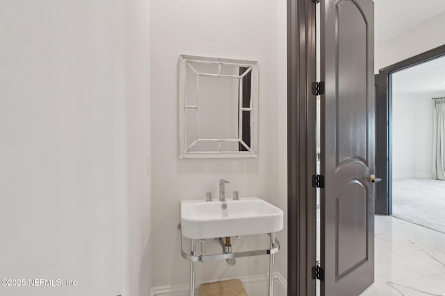 bathroom with a sink and marble finish floor