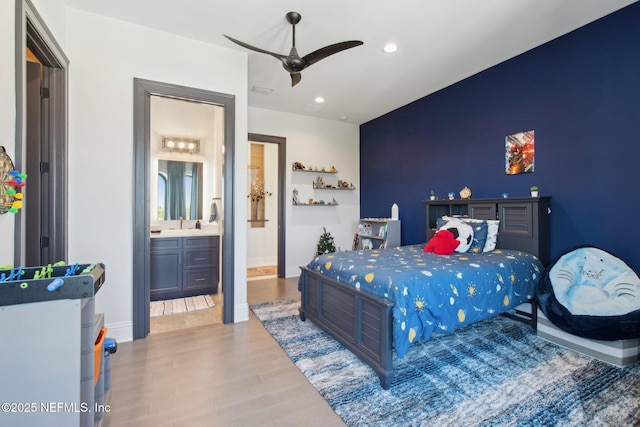 bedroom with a ceiling fan, wood finished floors, baseboards, recessed lighting, and connected bathroom