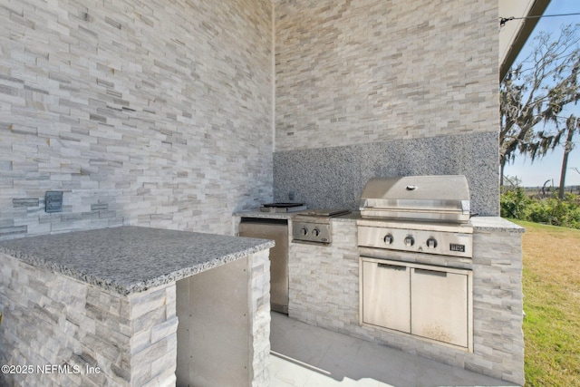 view of patio with an outdoor kitchen and a grill