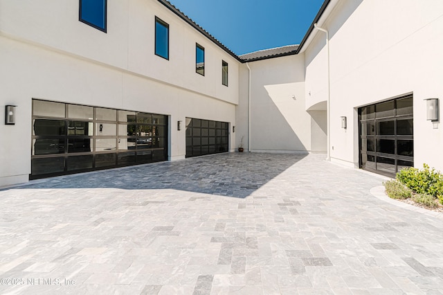 exterior space featuring decorative driveway and a garage