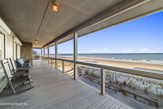 deck with a water view and a view of the beach