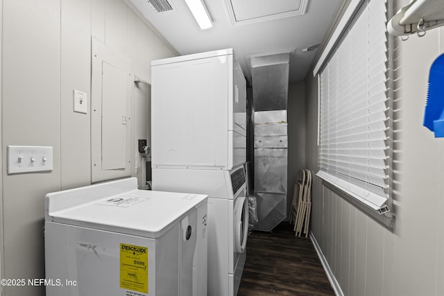 washroom featuring dark wood finished floors, laundry area, stacked washer and clothes dryer, and visible vents