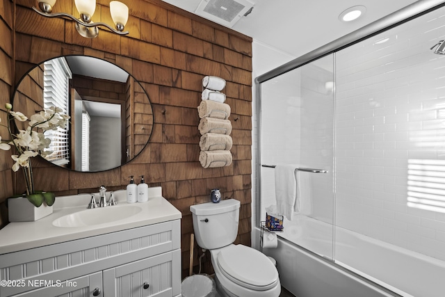 full bath with combined bath / shower with glass door, visible vents, toilet, and vanity