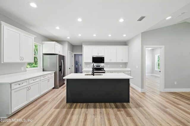 207 Palmetto Ave N, Florahome, FL 32140 - kitchen featuring appliances with stainless steel finishes, healthy amount of natural light, light wood-style floors, white cabinets, and recessed lighting