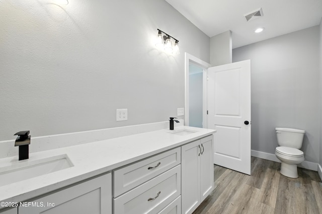 207 Palmetto Ave N, Florahome, FL 32140 - full bathroom with toilet, wood finished floors, double vanity, baseboards, and recessed lighting