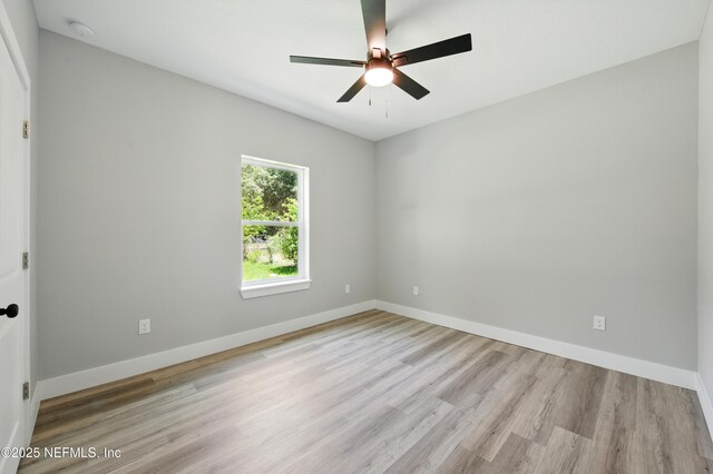 207 Palmetto Ave N, Florahome, FL 32140 - empty room with wood finished floors, a ceiling fan, a smoke detector, and baseboards