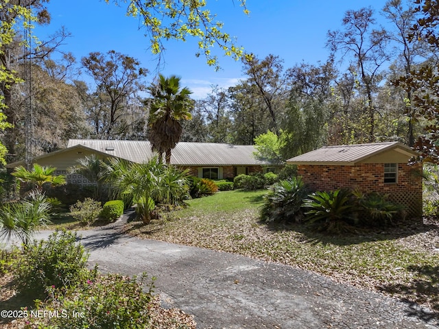 view of home's exterior featuring driveway and metal roof