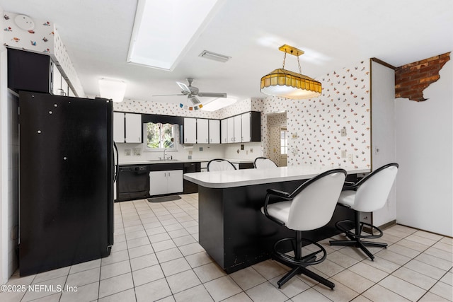 kitchen featuring black appliances, light tile patterned floors, light countertops, and a sink