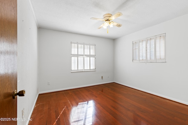 spare room with a textured ceiling, baseboards, a ceiling fan, and wood finished floors