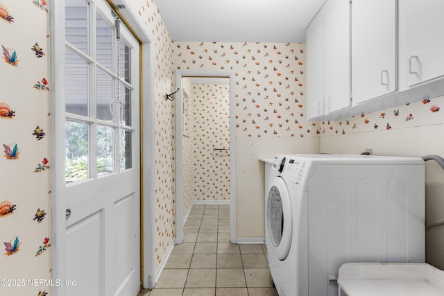 laundry area with wallpapered walls, baseboards, light tile patterned floors, cabinet space, and washer / clothes dryer