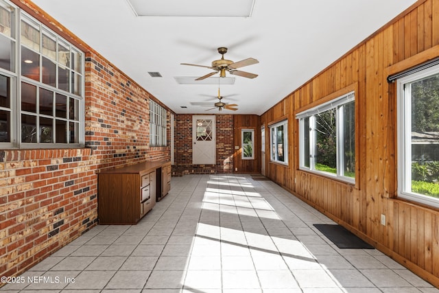 unfurnished sunroom featuring visible vents and ceiling fan