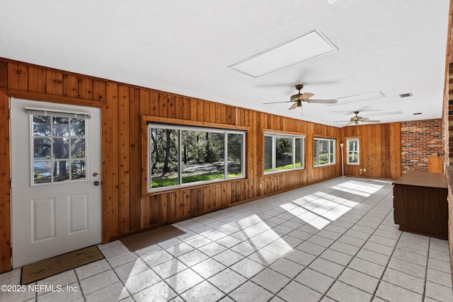 unfurnished sunroom with a wealth of natural light and a ceiling fan