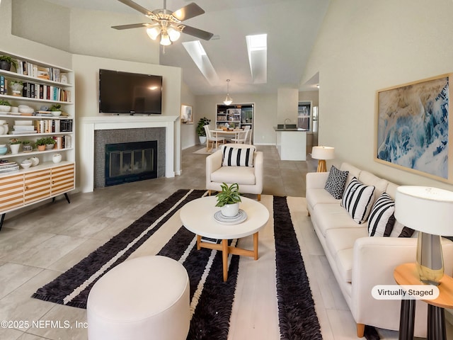 living area featuring a fireplace, a ceiling fan, and vaulted ceiling