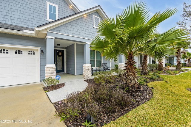 view of exterior entry featuring a garage, covered porch, and a yard