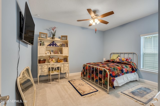 bedroom featuring baseboards, light carpet, and a ceiling fan