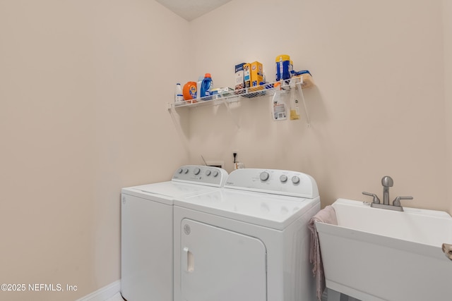 laundry room with laundry area, independent washer and dryer, baseboards, and a sink