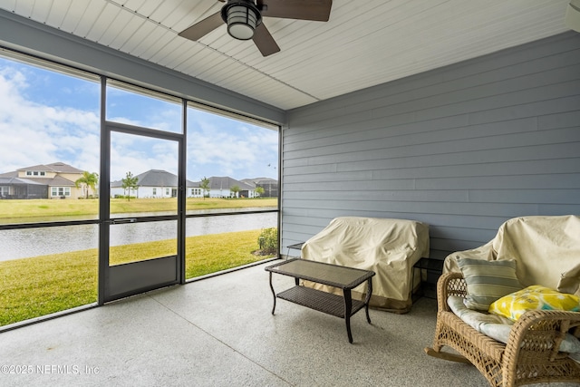 sunroom / solarium with a residential view, ceiling fan, and a water view