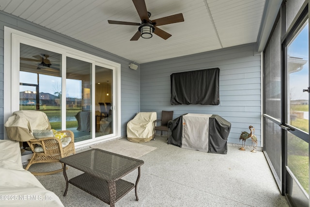 sunroom / solarium featuring a ceiling fan