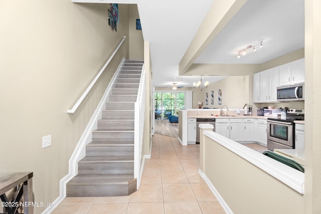 7540 Scarlet Ibis Ln, Jacksonville, FL 32256 - kitchen featuring light tile patterned flooring, a peninsula, stainless steel appliances, and a sink
