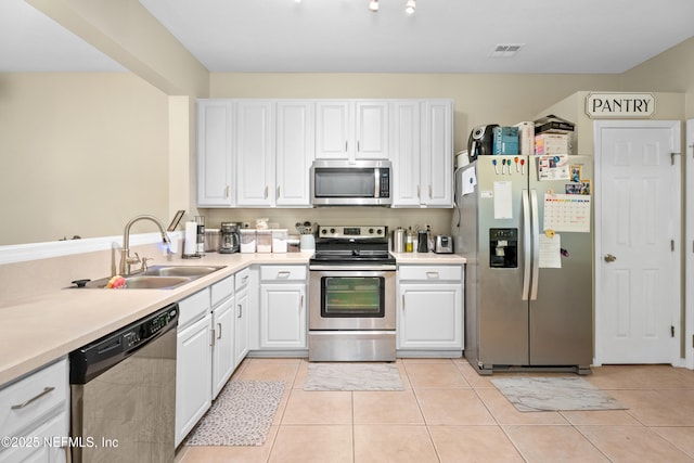 7540 Scarlet Ibis Ln, Jacksonville, FL 32256 - kitchen featuring light tile patterned floors, visible vents, a sink, appliances with stainless steel finishes, and white cabinetry